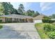 A one-story brick home with lush landscaping, a long driveway, and a side-entry garage at 1758 N Springs Dr, Atlanta, GA 30338