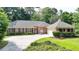 A charming single-story brick home with well-manicured landscaping, a large driveway, and a welcoming facade at 1758 N Springs Dr, Atlanta, GA 30338