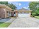 The garage of the brick home with a large driveway and well-manicured landscaping at 1758 N Springs Dr, Atlanta, GA 30338