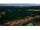 An aerial perspective highlighting the neighborhood's layout, proximity to a nearby lake, and lush green surroundings at dusk at 2377 Kesgrove Way, Buford, GA 30518