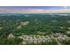 Expansive aerial view of the community surrounded by lush greenery and serene lake views in the distance at 2377 Kesgrove Way, Buford, GA 30518