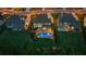 Aerial night view showcases an elegant home with a private backyard pool, lush lawn, and neighborhood setting at 2377 Kesgrove Way, Buford, GA 30518