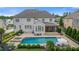 Aerial view shows a luxurious pool area with a hot tub, lounge chairs, stone-paved patio and back porch at 2377 Kesgrove Way, Buford, GA 30518
