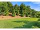 Large backyard with green grass, beautiful trees, and well-maintained landscaping at 2377 Kesgrove Way, Buford, GA 30518