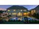 Twilight view of the backyard with a sparkling pool, hot tub, lounge area, and screened-in porch for evening relaxation at 2377 Kesgrove Way, Buford, GA 30518