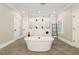 Stunning bathroom featuring a soaking tub, glass shower with multiple shower heads, and neutral color palette at 2377 Kesgrove Way, Buford, GA 30518