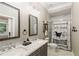 Stylish bathroom features a double sink vanity, marble countertops, decorative mirrors and shower at 2377 Kesgrove Way, Buford, GA 30518