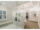 Elegant primary bathroom featuring a glass enclosed shower with soaker tub and dual vanities at 2377 Kesgrove Way, Buford, GA 30518