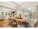 Bright dining room with coffered ceiling, a modern chandelier, and an open view of the living space at 2377 Kesgrove Way, Buford, GA 30518
