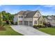 Rear exterior showcasing the house's three-car garage and well-maintained lawn at 2377 Kesgrove Way, Buford, GA 30518