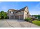 Stunning home featuring a three-car garage, neutral colors, manicured lawn, and classic architectural details at 2377 Kesgrove Way, Buford, GA 30518
