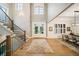 Elegant foyer with staircase, double doors, and hardwood floors leading to a dining area at 2377 Kesgrove Way, Buford, GA 30518