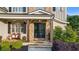 Charming front porch with stone steps, cozy seating, and stylish double doors at 2377 Kesgrove Way, Buford, GA 30518