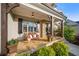 Inviting front porch featuring stone flooring, decorative plants, and a cozy bench for relaxing at 2377 Kesgrove Way, Buford, GA 30518