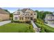 Beautifully landscaped front yard with lush greenery, stone accents, and manicured lawn at 2377 Kesgrove Way, Buford, GA 30518