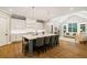Open kitchen featuring a center island with seating, hardwood floors, and access to a spacious living area at 2377 Kesgrove Way, Buford, GA 30518