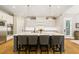 Modern kitchen with a large island, white cabinets, stainless steel appliances, and hardwood floors at 2377 Kesgrove Way, Buford, GA 30518