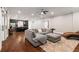 Open-concept living room with modern sectional, hardwood floors, and adjacent kitchen for easy entertaining at 2377 Kesgrove Way, Buford, GA 30518