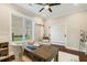 Bright office space featuring a modern ceiling fan, wooden desk, and comfortable chair at 2377 Kesgrove Way, Buford, GA 30518