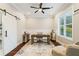 Bright office with dark wood floors, ceiling fan, a desk and sliding barn door at 2377 Kesgrove Way, Buford, GA 30518