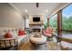 Inviting screened-in porch with stone flooring, fireplace, and comfortable seating arrangement at 2377 Kesgrove Way, Buford, GA 30518