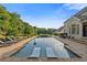 Backyard pool boasts sunbeds for lounging and lush landscaping for added seclusion and tranquility at 2377 Kesgrove Way, Buford, GA 30518