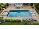 Aerial view displays a luxurious pool area with a hot tub, lounge chairs, and stone-paved patio at 2377 Kesgrove Way, Buford, GA 30518