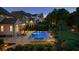 Inviting backyard pool area with pristine landscaping, comfortable seating, and tasteful outdoor lighting at twilight at 2377 Kesgrove Way, Buford, GA 30518