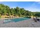 A luxurious backyard pool area includes sun loungers, a spa, and mature trees offering privacy and shade at 2377 Kesgrove Way, Buford, GA 30518