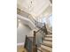 Grand staircase with wooden handrails and black wrought iron spindles and geometric light fixture at 2377 Kesgrove Way, Buford, GA 30518