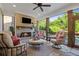 Comfortable sunroom with stone fireplace, ceiling fan, brick wall, and oversized windows with a view at 2377 Kesgrove Way, Buford, GA 30518