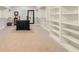 Spacious walk-in closet with custom shelving, carpeted floor and center island for storing clothes and accessories at 2377 Kesgrove Way, Buford, GA 30518