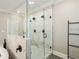 A modern walk-in shower features white marble-style tile and glass enclosure at 2377 Kesgrove Way, Buford, GA 30518