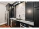 Modern wet bar with stainless steel appliances, granite countertops, and sleek black cabinets at 2377 Kesgrove Way, Buford, GA 30518