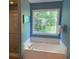 Soaking tub in the primary bathroom with a large window and separate glass shower at 340 Fountainmist Trl, Lawrenceville, GA 30043