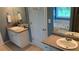 Bright bathroom featuring double sink vanity, a white door, and a relaxing tub by the window at 340 Fountainmist Trl, Lawrenceville, GA 30043