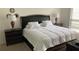 Cozy bedroom featuring a large bed with a dark wood frame and side tables with lamps at 340 Fountainmist Trl, Lawrenceville, GA 30043