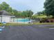 Community pool surrounded by a fence, with chairs and umbrellas for residents' comfort at 340 Fountainmist Trl, Lawrenceville, GA 30043