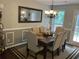 Formal dining room featuring wainscoting, a decorative mirror, and seating for six at 340 Fountainmist Trl, Lawrenceville, GA 30043