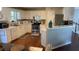 Bright kitchen featuring white cabinets, a breakfast bar, stainless steel appliances, and hardwood floors at 340 Fountainmist Trl, Lawrenceville, GA 30043