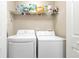 Functional laundry room includes a washer, dryer, and shelving for storage at 5365 Twin Creeks Dr, Norcross, GA 30071