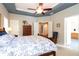Comfortable bedroom features a tray ceiling, ceiling fan, and ensuite bathroom at 5365 Twin Creeks Dr, Norcross, GA 30071