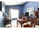 Office featuring blue walls, multiple workspaces, and natural light from a window at 5365 Twin Creeks Dr, Norcross, GA 30071