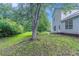 Backyard featuring a grassy lawn and trees surrounding a two story home at 5421 Salem Springs Dr, Lithonia, GA 30038