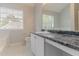 Bright bathroom with white cabinets, granite countertop, and a window providing natural light at 5421 Salem Springs Dr, Lithonia, GA 30038