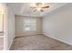 Serene main bedroom features a tray ceiling with fan, large window, and neutral carpeting at 5421 Salem Springs Dr, Lithonia, GA 30038