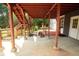 Backyard with a covered deck area, landscaping, and lawn mower on a concrete patio at 1851 Harvest Way, Loganville, GA 30052