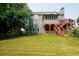 Backyard featuring a tiered deck, screened in porch and mature shade trees on a grassy lawn at 1851 Harvest Way, Loganville, GA 30052