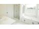 Bright bathroom featuring a glass-enclosed shower, soaker tub with cabinets, and bright white vanity at 1851 Harvest Way, Loganville, GA 30052