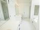 Bright primary bathroom with white double vanity, tiled floors, standalone shower, and a separate tub at 1851 Harvest Way, Loganville, GA 30052